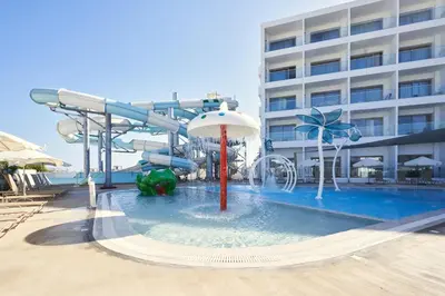 a water slide in a pool in front of a hotel at Maris Grand Waterpark Resort in Protaras