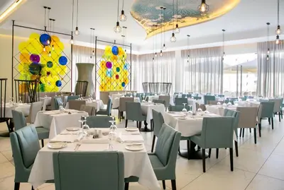 a dining room with white tables and chairs and balloons at Vangelis Hotel & Suites in Protaras