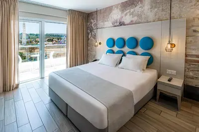 a bedroom with a large bed and a large window at Vangelis Hotel & Suites in Protaras