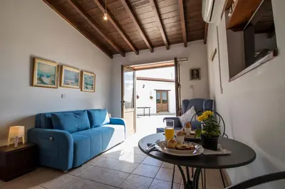 a living room with a blue couch and a table at Samareitidos Light Cottage in Anaphotia