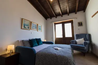a living room with a bed and a blue couch at Samareitidos Light Cottage in Anaphotia