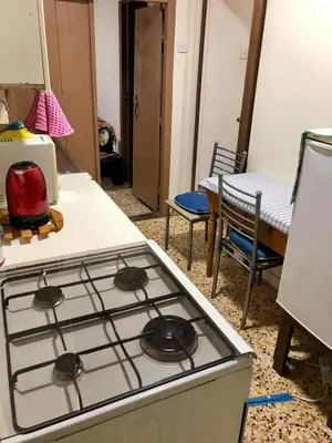 a stove top oven in a kitchen next to a table at Saint Nicholas heights in Chakistra