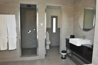 a bathroom with a shower and a sink and a toilet at E-Hotel Larnaca Resort & Spa in Larnaka