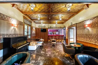 a bar with a piano and tables and chairs at Forest Park Hotel in Platres