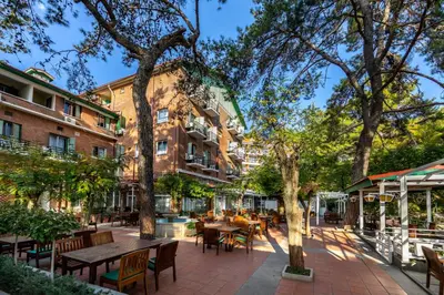 a patio with tables and chairs in front of a building at Forest Park Hotel in Platres