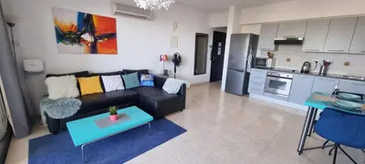 a living room with a black couch and a kitchen at Mazotos Hills 3 in Mazotos