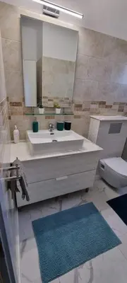 a bathroom with a sink and a mirror and a toilet at Mazotos Hills 3 in Mazotos