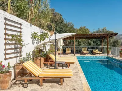 a swimming pool with two lounge chairs and an umbrella at Kalavasos Square Apartments - With Access to Shared Pool 3 Minutes Walk in Kalavasos