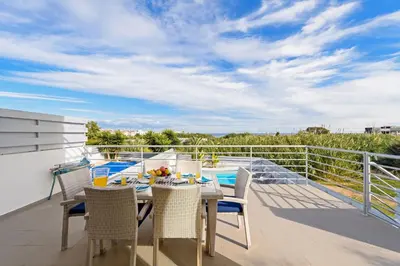 a patio with a table and chairs on a balcony at Ayia Triada View in Protaras