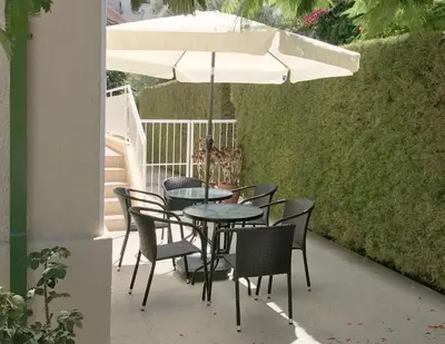a table and chairs under an umbrella on a patio at Avgi's Home in Limassol