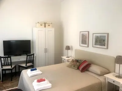 a bedroom with a bed and a desk with a television at Avgi's Home in Limassol