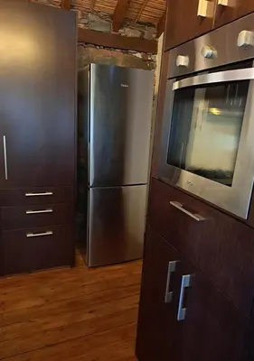 a kitchen with a stainless steel refrigerator and a microwave at To Apokentro in Alona