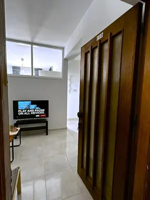 an open door in a living room with a tv at Engomi Apartment in Yukarı Lakatamya