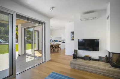 a living room with a large flat screen tv and a large window at Protaras Villa Zen in Protaras