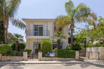 a house with palm trees in front of it at Villa Mesogeios 39 in Paralimni