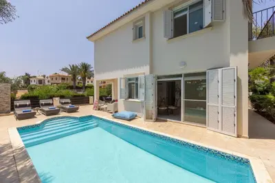 a villa with a swimming pool in front of a house at Villa Mesogeios 39 in Paralimni