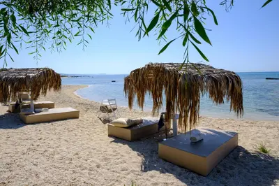a beach with chairs and umbrellas on the sand at Thalassines Villas in Ayia Napa