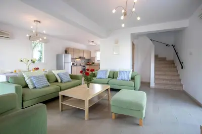 a living room with green couches and a table at Villa Costas in Protaras