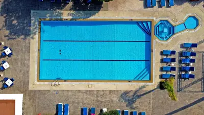 an overhead view of a large swimming pool with chairs at Green Bungalows Hotel Apartments in Ayia Napa