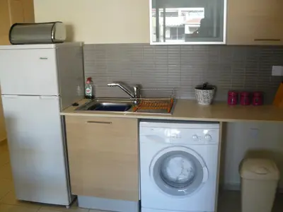 a kitchen with a washing machine and a sink at Pyla Gardens E108 in Pyla