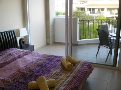 a bedroom with a bed with yellow towels on it at Pyla Gardens E108 in Pyla
