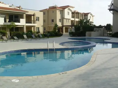 a swimming pool in front of some apartment buildings at Pyla Gardens E108 in Pyla