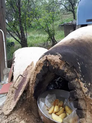 a stone oven with a bowl of food in it at Agrompelo House in Agros