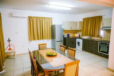 a kitchen with a dining room table with chairs and a tableablish at Villa Costa Cornelia Homes in Ayia Napa