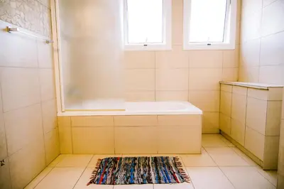 a bathroom with a shower and a tub and a rug at Villa Costa Cornelia Homes in Ayia Napa