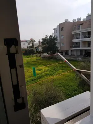 a yard with a green field with a building at Strovolos rooms Studios in Nicosia