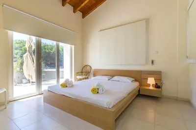 a bedroom with a large bed and a large window at Marina Estate in Protaras