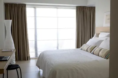 a bedroom with a bed and a large window at Sandy Beach Hotel & Spa - ex Sentido in Larnaka