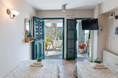 a room with two tables and a door with a patio at Themis House in Lemithou