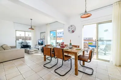 a kitchen and living room with a table and chairs at Sunrise Bay Villa #1 in Paralimni