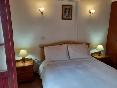 a bedroom with a white bed with two lamps on night stands at Niovi House in Tochni