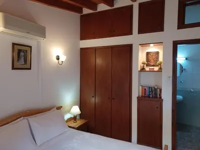 a bedroom with a bed and a cabinet and a bathroom at Niovi House in Tochni