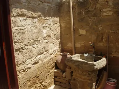 a stone room with a stone wall and a vase at Niovi House in Tochni