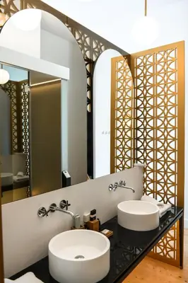 a bathroom with two sinks and a mirror at S Paul City Hotel in Limassol