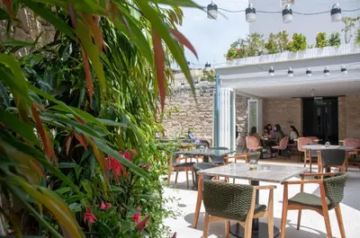 a patio with tables and chairs and plants at S Paul City Hotel in Limassol