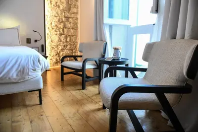 a bedroom with two chairs and a bed and a window at S Paul City Hotel in Limassol