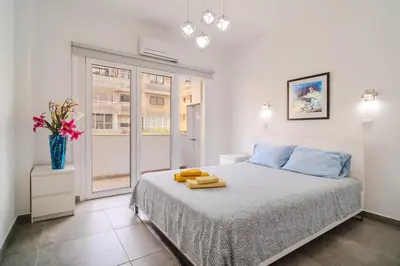 a bedroom with a bed with a vase of flowers on it at City Rendezvous One Bedroom Flat in Larnaka