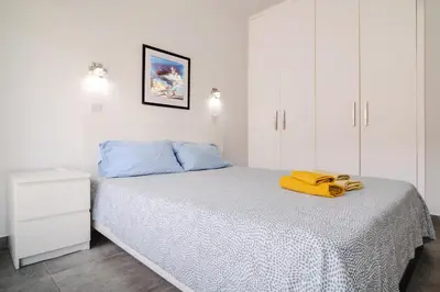 a bedroom with a bed with a yellow towel on it at City Rendezvous One Bedroom Flat in Larnaka