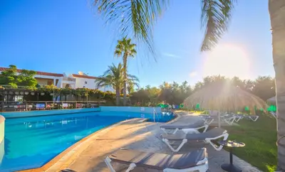 a swimming pool with chaise lounge chairs and a resort at Captain Karas Holidays Apartments in Protaras