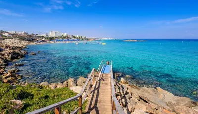 a wooden bridge over the water near a beach at Villa Penelope in Protaras