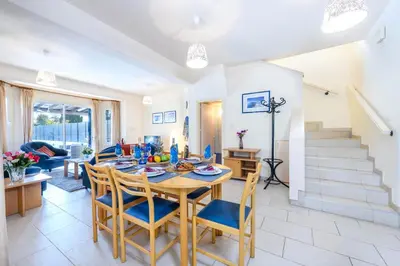 a dining room and living room with a table and chairs at Villa Penelope in Protaras