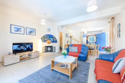 a living room with a couch and a tv and a table at Villa Penelope in Protaras