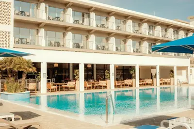 a hotel with a swimming pool in front of a building at Sveltos Hotel in Larnaka