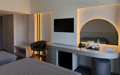 a hotel room with a bed and a desk with a television at Sveltos Hotel in Larnaka