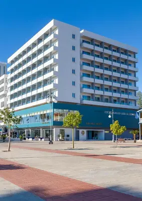 a large white building with trees in front of it at Sun Hall Hotel in Larnaka