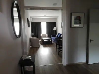 a hallway with a living room and a mirror at Sun Hall Beach Hotel Apartments in Larnaka